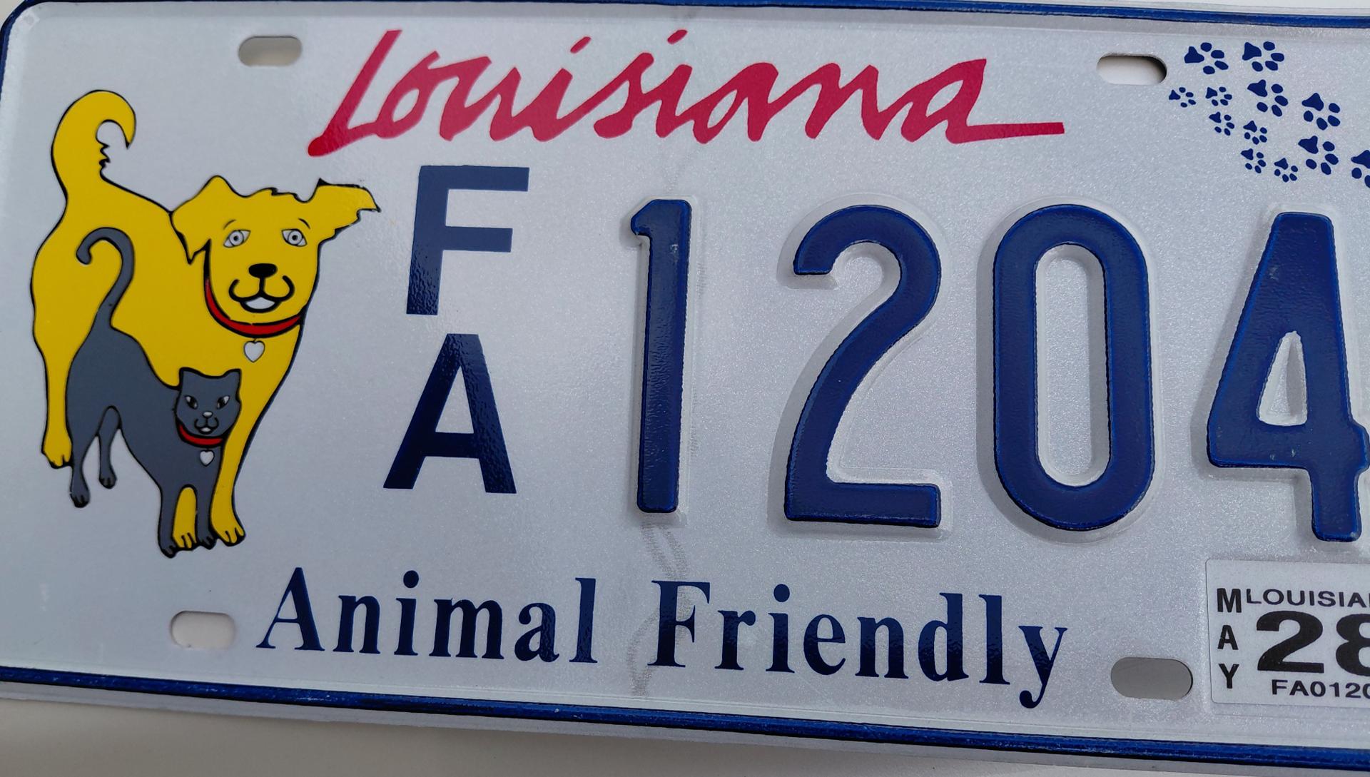 A real Louisiana Animal Friendly license plate featuring the yellow dog and gray cat design